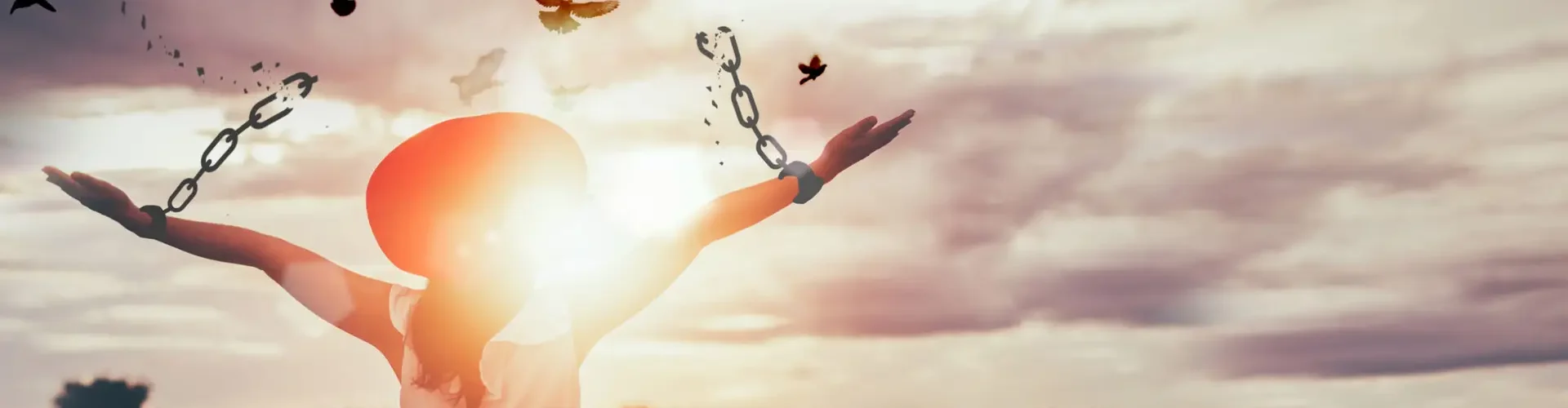 The woman is breaking the chains and setting the birds free, enjoying the nature at sunrise. concept of freedom